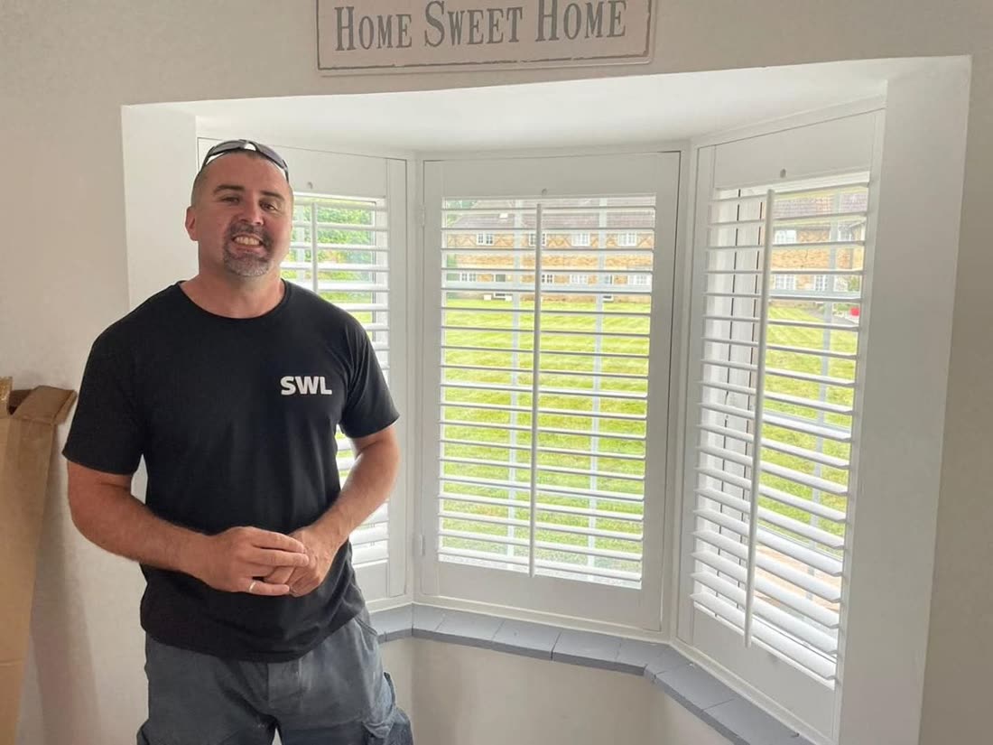Shutters West London fitter beside a newly fitted white bay window shutter installation